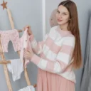 Zwangere vrouw legt babykleding klaar volgens haar baby uitzetlijst