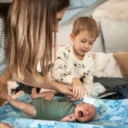 Ouder borstelt voorzichtig het hoofdje van een baby met berg