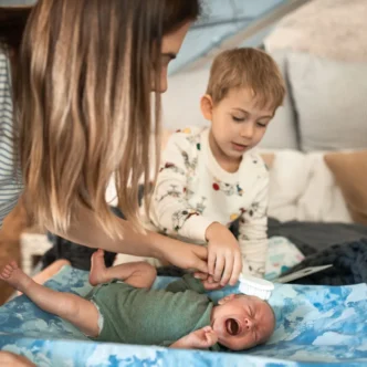 Ouder borstelt voorzichtig het hoofdje van een baby met berg