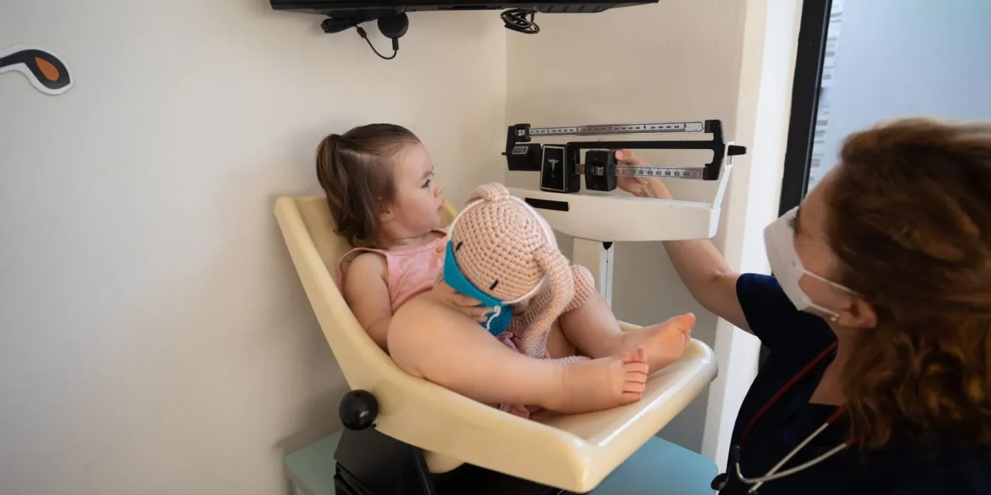 Baby wordt gewogen op het consultatiebureau voor de groeicurve baby