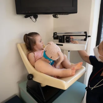 Baby wordt gewogen op het consultatiebureau voor de groeicurve baby