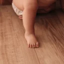 Baby die op handen en knieën over de vloer kruipt
