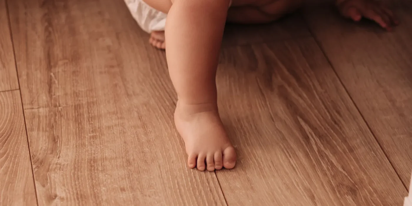 Baby die op handen en knieën over de vloer kruipt