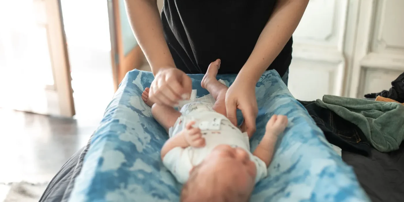 Ouder verschoont de luier van een baby om luieruitslag te voorkomen