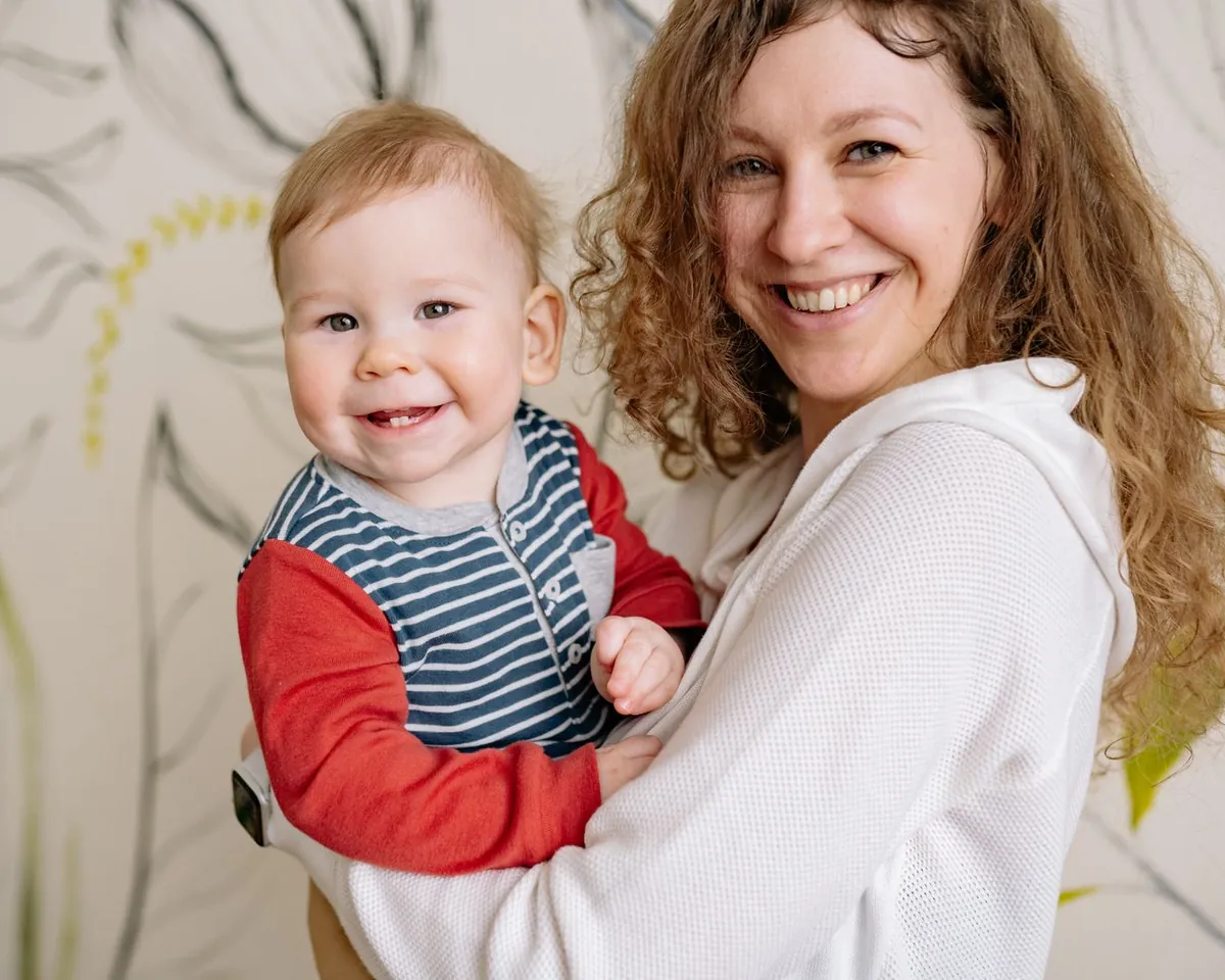Lachende moeder houdt haar vrolijke baby vast