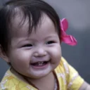 Lachende baby met de eerste tandjes bijt op een bijtring